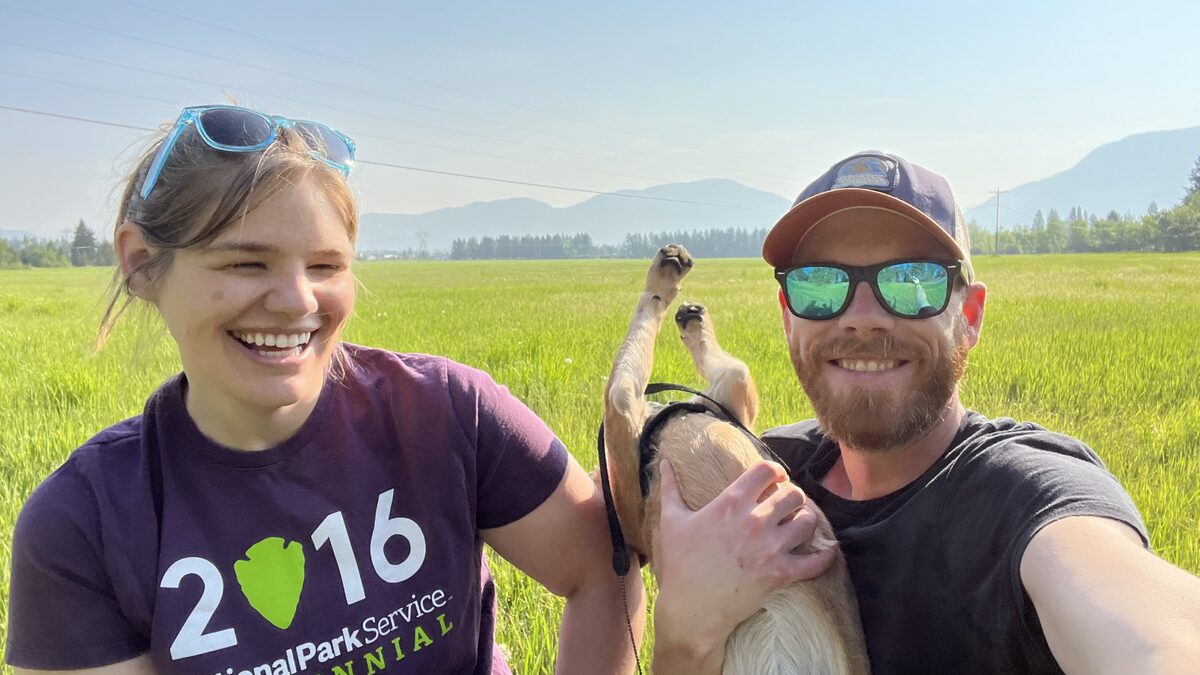 Mark with Beck and Sinopah in a Montana field, mountains behind